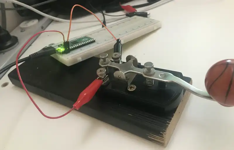 Morse key screwed to a scrap of wood and the Pico on a breadboard for testing
